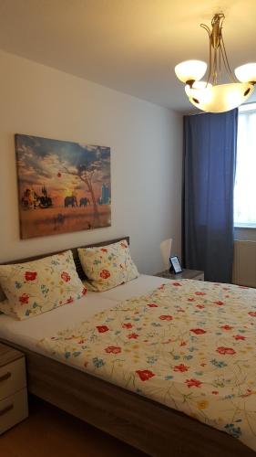 a bedroom with a bed and a painting on the wall at Altstadtapartment an der Krämerbrücke in Erfurt