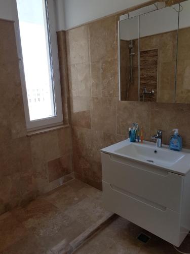 a bathroom with a sink and a mirror at Biandada Apartments in Mamaia Sat/Năvodari