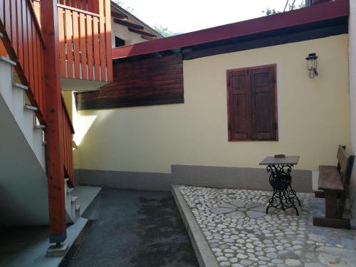 a courtyard with a door and a table and stairs at Hiša Kranjc in Kobarid