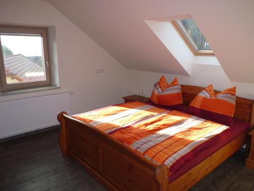 ein Schlafzimmer mit einem Holzbett mit orangefarbenen Kissen in der Unterkunft Ferienbauernhof Koller (Familie Hofer) - Urlaub am Bauernhof in Helfenberg