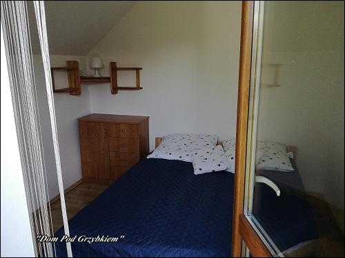 a small bedroom with a bed and a mirror at "Dom Pod Grzybkiem" in Krościenko