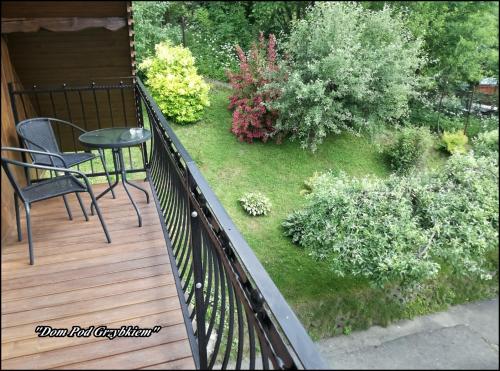 a wooden deck with a table and chairs on a garden at "Dom Pod Grzybkiem" in Krościenko