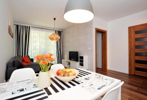 a living room with a table with a bowl of fruit on it at Apartament 27 Dwie Sosny in Ustronie Morskie