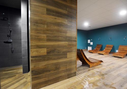 a waiting room with chairs and a wall of wood at Apartament 27 Dwie Sosny in Ustronie Morskie