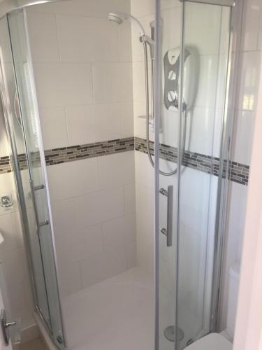y baño con ducha y puerta de cristal. en The Retreat en Charmouth