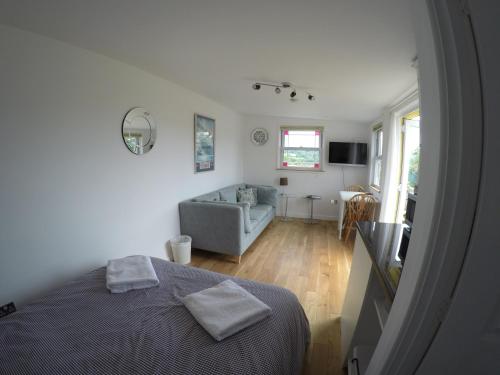a bedroom with a bed and a couch in a room at The Retreat in Charmouth