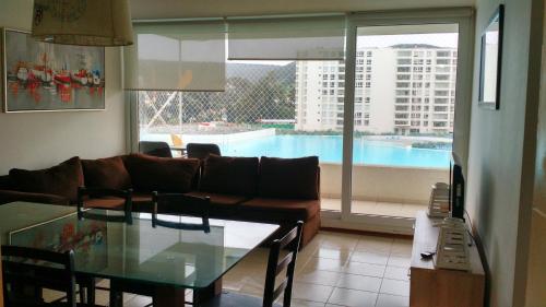 sala de estar con sofá y mesa de cristal en Apartamento Papudo Laguna 511B, en Papudo