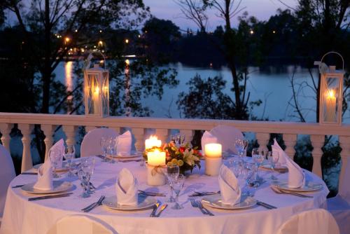 a table with candles and flowers on a white table cloth at Margarona Royal Hotel in Preveza