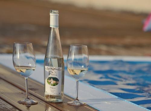 uma garrafa de vinho branco ao lado de dois copos de vinho em Penzion Prefila em Bulhary