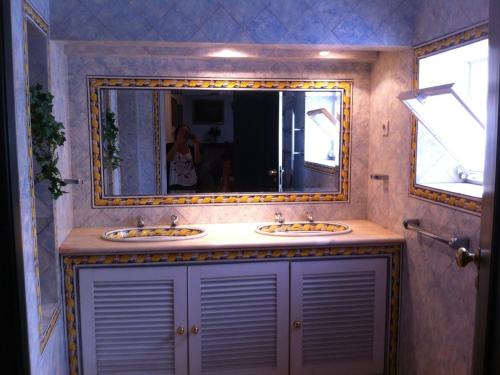 a bathroom with two sinks and a large mirror at Casa da Lagoa Guest House in Évora