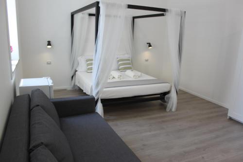 a living room with a couch and canopy beds at Dimora di Artemide in Siracusa