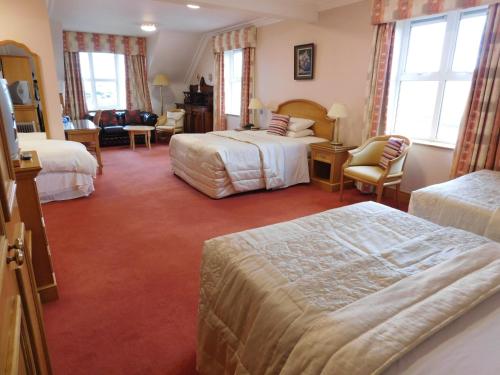 una camera d'albergo con due letti e un soggiorno di Cashen Course House a Ballybunion