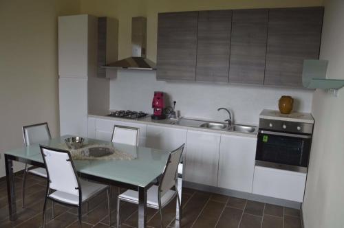 Una cocina con una mesa y sillas y un fregadero. en Il Piccolo Principe, en Cairano