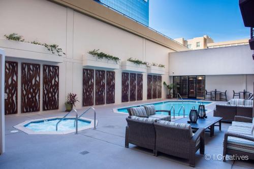 una piscina con sillas y una mesa junto a un edificio en Best Western Plus Bayside Inn, en San Diego