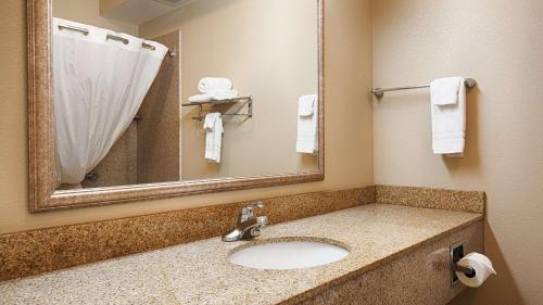 a bathroom with a sink and a mirror and towels at Best Western Inn & Suites - Henrietta in Henrietta