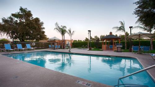 uma grande piscina com cadeiras e um gazebo em Best Western Plus Fresno Airport Hotel em Fresno