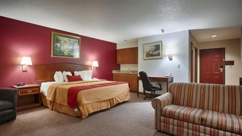 een hotelkamer met een bed en een bank bij Best Western Okmulgee in Okmulgee