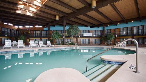 ein großer Pool mit Stühlen in einem Hotel in der Unterkunft Best Western Starlite Village in Fort Dodge
