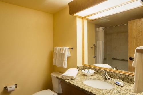 a bathroom with a sink and a toilet and a mirror at Best Western Plus Caldwell Inn & Suites in Caldwell
