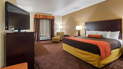 a hotel room with a bed and a flat screen tv at Best Western Plus Goliad Inn & Suites in Goliad
