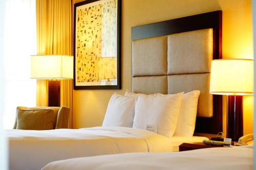a hotel room with two beds and two lamps at Wyndham Chicago O'Hare in Rosemont