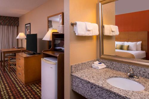a hotel room with a sink and a mirror at Best Western Ambassador Inn & Suites in Wisconsin Dells