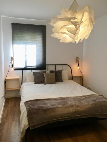 um quarto com uma cama grande e um lustre em Lisbon Woods House em Lisboa