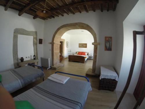 sala de estar con 2 camas y sofá en Casa das Andorinhas, en Alpalhão