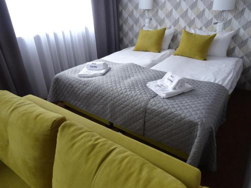 two beds in a hotel room with towels on them at Carina Hotel in Tczew