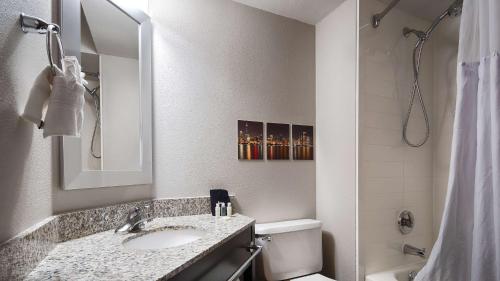 a bathroom with a sink and a toilet and a mirror at Best Western O'Hare/Elk Grove Hotel in Elk Grove Village