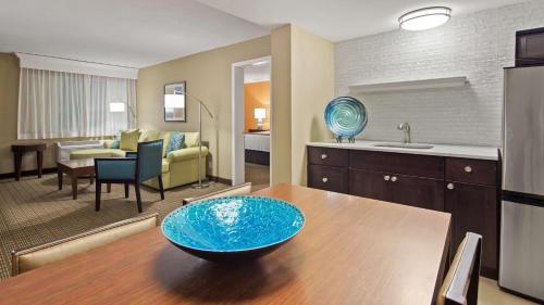 a kitchen and living room with a blue bowl on a table at Best Western Palm Beach Lakes in West Palm Beach