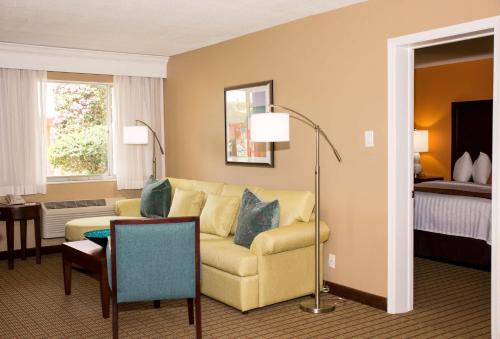 a living room with a couch and a table at Best Western Palm Beach Lakes in West Palm Beach
