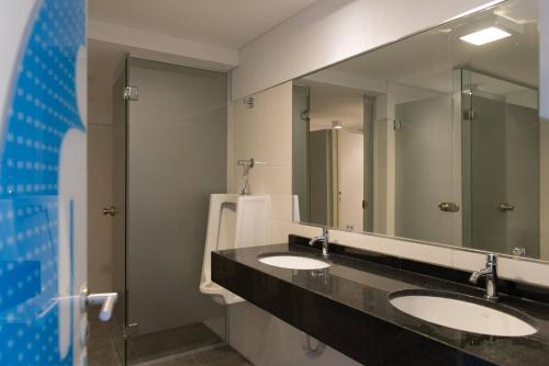 a bathroom with two sinks and a large mirror at Nueva Córdoba Duomo in Córdoba