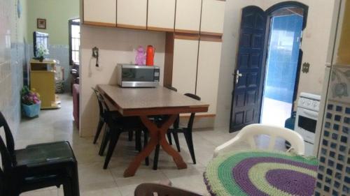 a kitchen with a table with a microwave on it at Casa Lado Praia Bom Espaco in Praia Grande