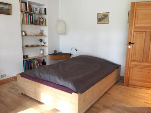 a bed in a bedroom with a wooden bed frame at LindegaardApartment - woods and sea in Hejls