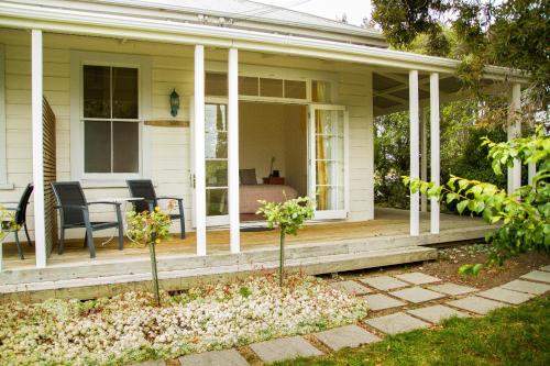 a porch of a house with a table and chairs at Margrain Vineyard Villas in Martinborough 