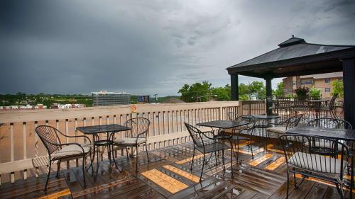 a patio area with tables, chairs and umbrellas at Best Western Plus Landing View Inn & Suites in Branson