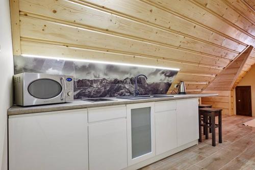 a kitchen with a microwave on top of a counter at Aga in Suche