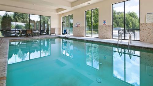 a swimming pool with blue water in a building with windows at Best Western Plus Battleground Inn & Suites in Battle Ground