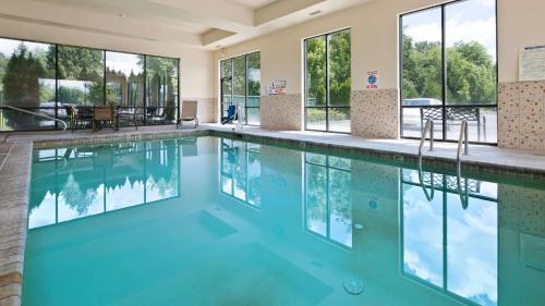 a swimming pool with blue water in a building with windows at Best Western Plus Battleground Inn & Suites in Battle Ground