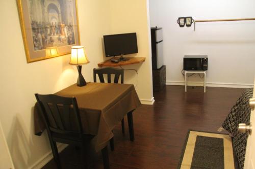 a living room with a table and a television at Summer Leaf in Reseda