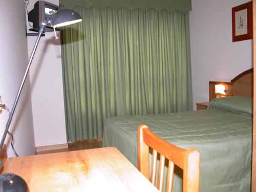 a bedroom with a bed and a table with a lamp at Hotel Costa Verde in Neaño