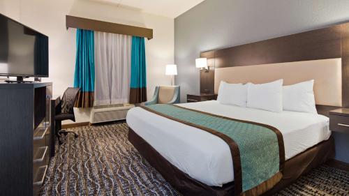 Habitación de hotel con cama y TV de pantalla plana. en Best Western Waldo Inn & Suites en Waldo