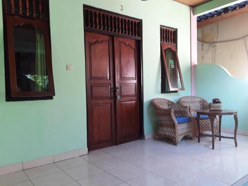 a room with a wooden door and a table and chairs at Blue Star Bungalows & Cafe in Amed
