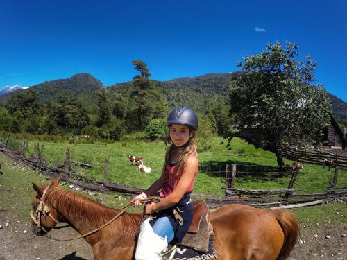 a young girl riding a horse in a field at Barraco Lodge in Puelo