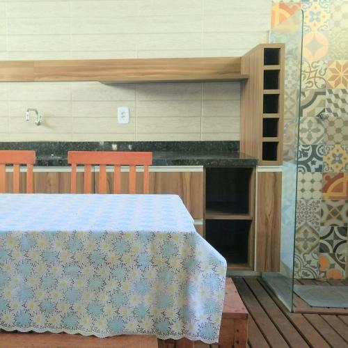 a kitchen with a table with chairs and a counter at Linda Casa de Praia em Itacimirim in Itacimirim