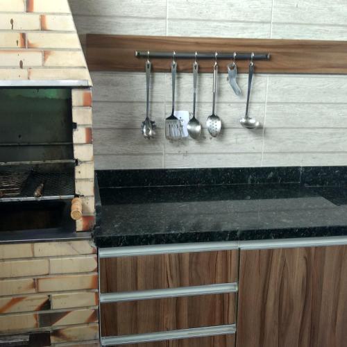 a kitchen with utensils hanging on a wall at Linda Casa de Praia em Itacimirim in Itacimirim