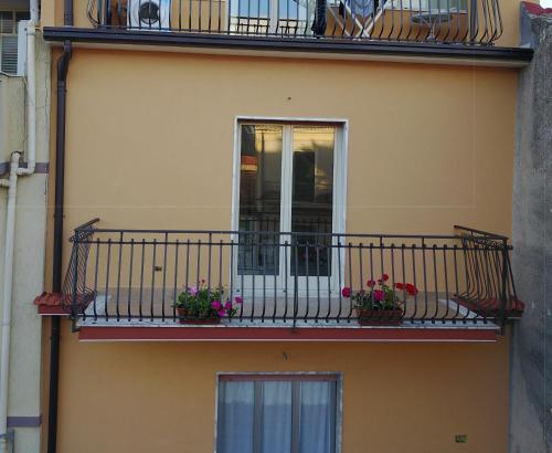 a building with two balconies with flowers on it at Casa Catena in Francavilla di Sicilia