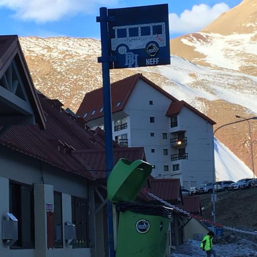 a building with a bus sign on top of it at Dormy Houses Payen in Las Lenas