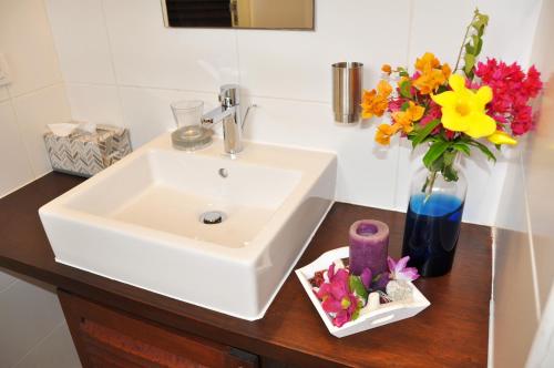 a bathroom sink with a vase of flowers on a counter at Hilltop Sea view , Boca Gentil in Willemstad